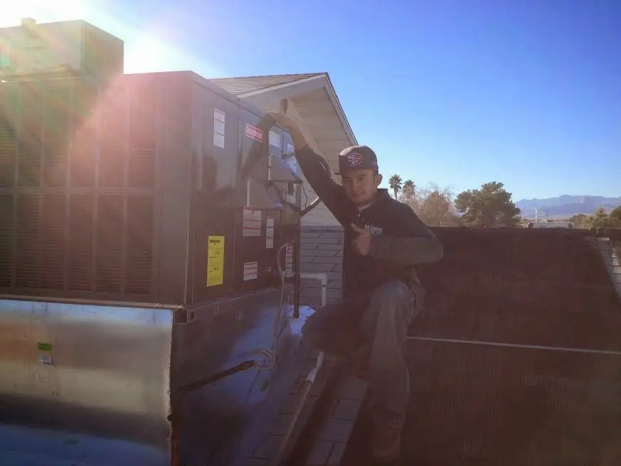 HVAC technician performing AC Tune-Up on a rooftop unit in El Mirage